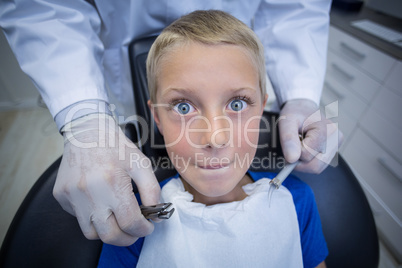 Dentist examining a young patient with tools