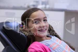 Smiling young patient sitting on dentists chair