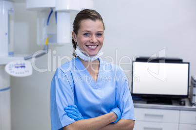 Smiling dental assistant standing with arms crossed