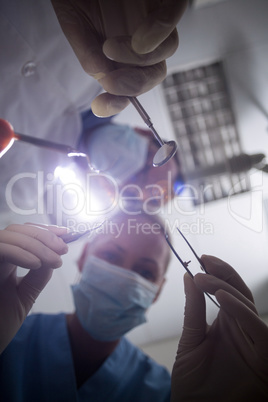 Dentist in surgical mask holding dental tools