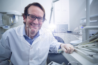 Portrait of smiling dentist sitting on chair