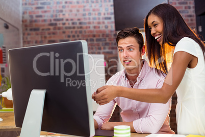 Businesswoman interacting with coworker while working on compute