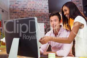 Businesswoman interacting with coworker while working on compute