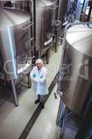 Smiling manufacturer standing at brewery