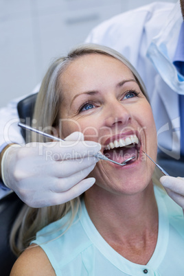 Dentist examining a woman with tools