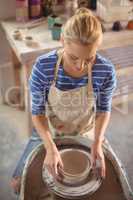 Beautiful female potter making pot