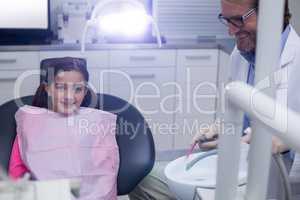 Smiling young patient sitting on dentists chair