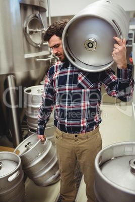 Manufacturer carrying kegs in brewery
