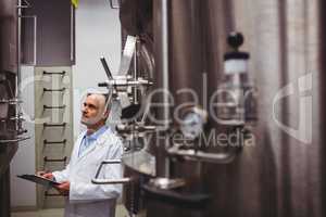 Manufacturer looking at storage tanks in brewery