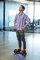 Graphic designer standing on hoverboard in office