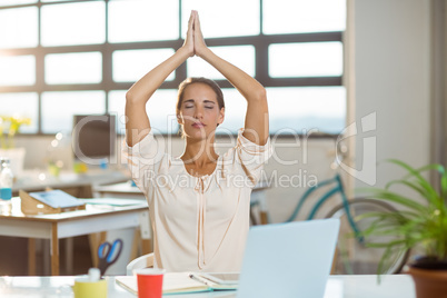 Female business executive performing yoga