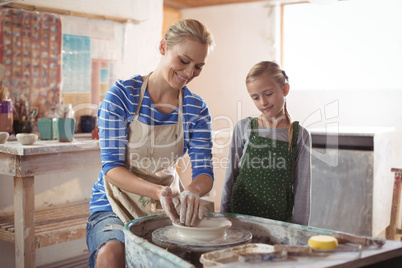 Female potter assisting girl
