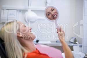 Patient checking her teeth in mirror