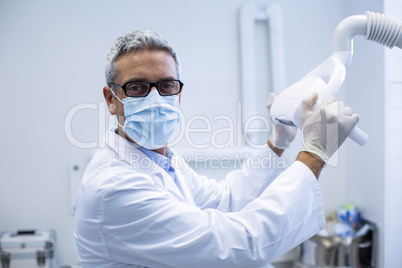 Portrait of a dentist adjusting light