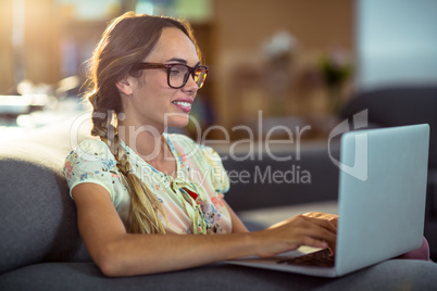 Woman sitting on chair and using laptop in office