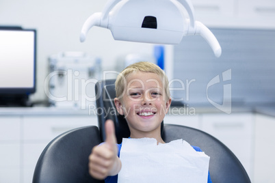 Smiling young patient sitting on dentist chair