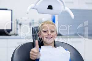 Smiling young patient sitting on dentist chair