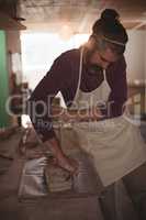 Male potter designing clay with stick