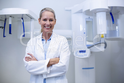 Portrait of female dentist smiling with arms crossed