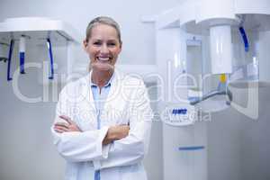 Portrait of female dentist smiling with arms crossed