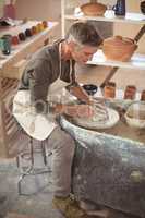 Male potter making pot in pottery workshop