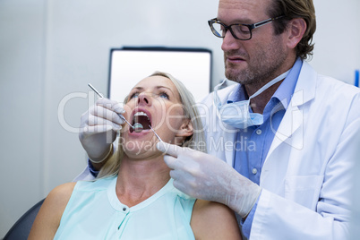 Dentist examining a woman with tools