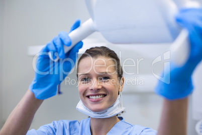 Portrait of dental assistant adjusting light