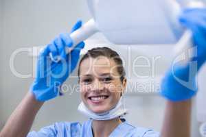 Portrait of dental assistant adjusting light