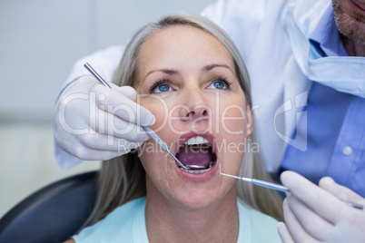 Dentist examining a woman with tools