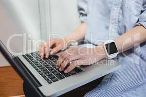 Woman using laptop in locker room