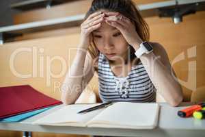 Tensed young woman sitting in classroom