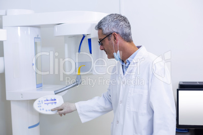 Dental dentist adjusting x-ray equipment