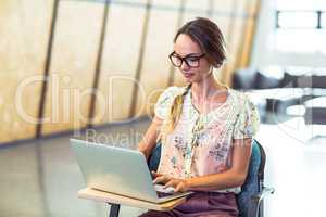 Woman sitting on chair and using laptop