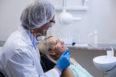 Dentist examining a woman with tools