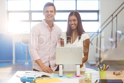 Business people standing with a laptop