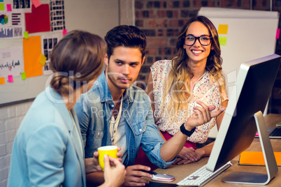 Graphic designers discussing over computer