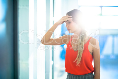 Tired businesswoman leaning on wall