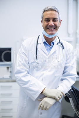 Smiling dentist standing in dental clinic