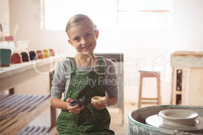 Portrait of happy girl holding bowl