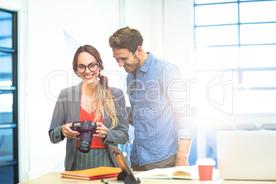 Business executives checking photos in camera
