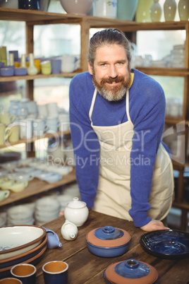 Portrait of male potter standing at table