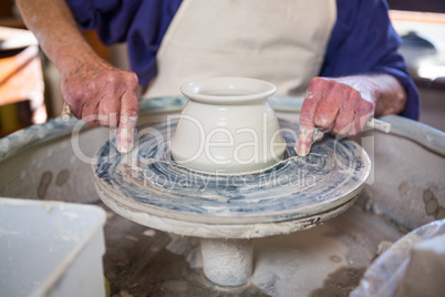 Mid section of potter making pot