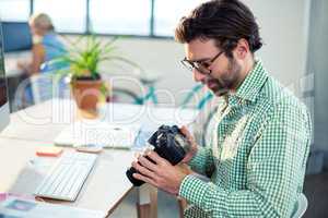 Graphic designer looking at pictures in digital camera