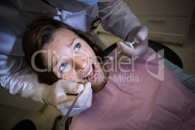 Dentist injecting female patient