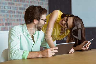Business executive and co-worker interacting while using digital