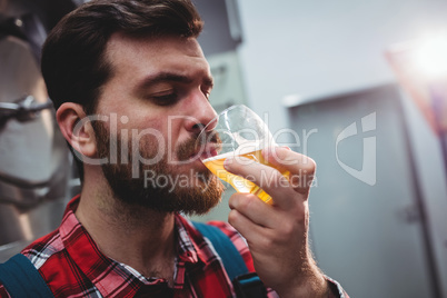 Close-up of manufacturer tasting beer