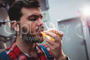 Close-up of manufacturer tasting beer