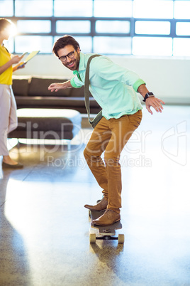 Male business executive riding skateboard