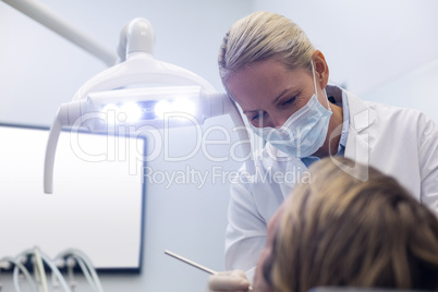 Dentist examining a patient with tools