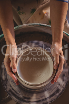 Close-up of female potter making pot